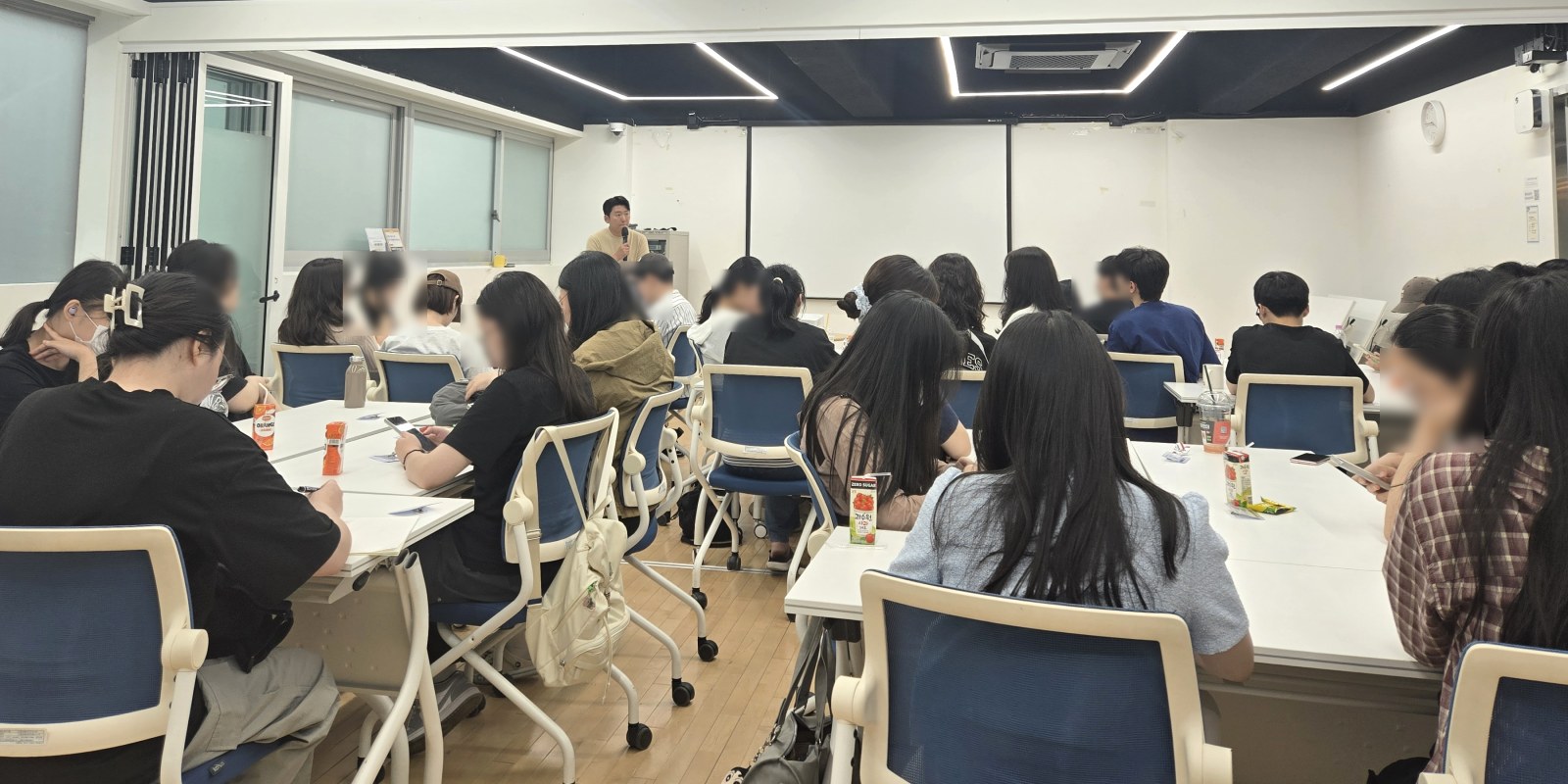 모티브이노베이션 강사가 마이크를 잡고 40여 명 앞에서 강의를 진행하는 모습