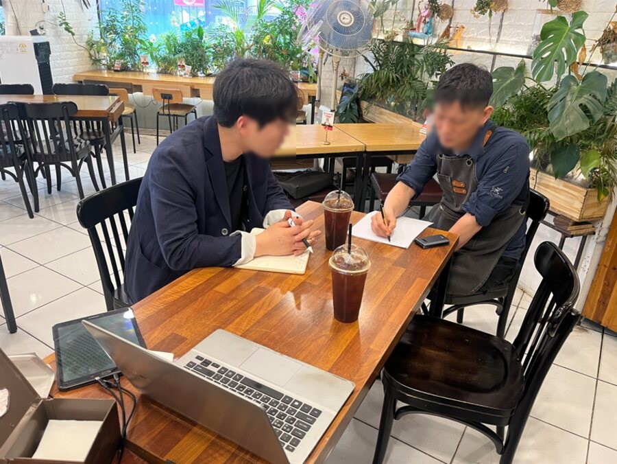 대구 장*뚝배기 매장에서 모티브이노베이션 컨설턴트가 공*훈 대표와 마주 앉아 컨설팅을 진행하는 모습